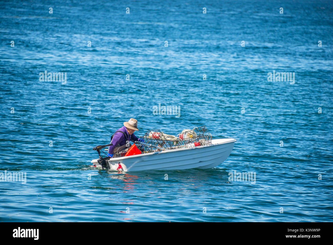 Pêcheur de crabe sur l'eau dans son petit canot Banque D'Images