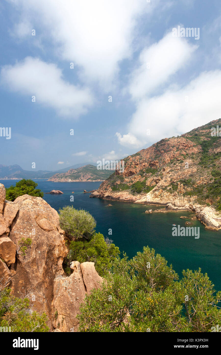 Nuages et ciel bleu sur la mer bleue entourée de falaises de granit et les plantes Porto Corse-du-Sud France Europe Banque D'Images