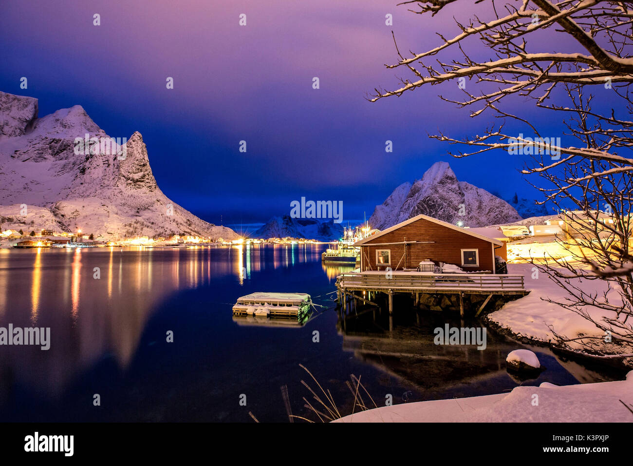 Un Rorbu, le norvégien typique maison de pêcheurs, se reflétant dans les eaux de la mer à l'heure bleue en reine, îles Lofoten, Norvège. L'Europe Banque D'Images