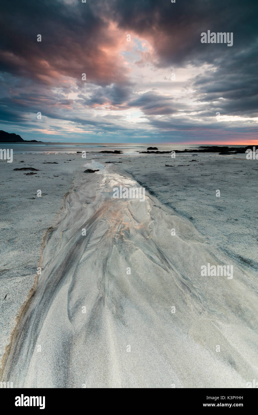 Soleil de minuit et les nuages frame la plage de sable de Skagsanden Flakstad Nordland County Iles Lofoten Norvège Europe Banque D'Images