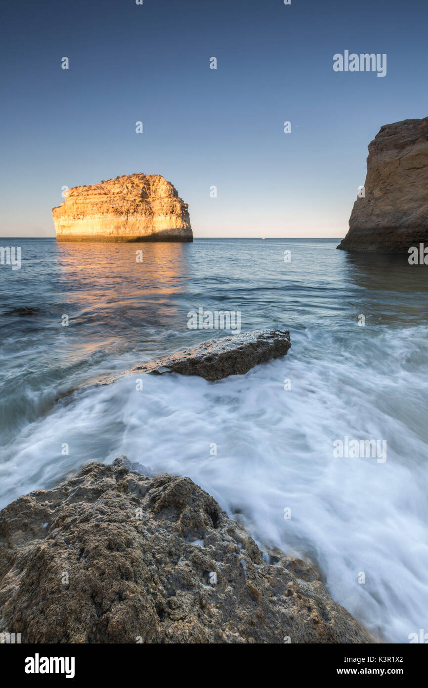 Les vagues de l'océan s'écraser sur les rochers au lever de Praia de Albandeira Caramujeira Carvoeiro Lagoa Algarve Portugal Europe Municipalité Banque D'Images