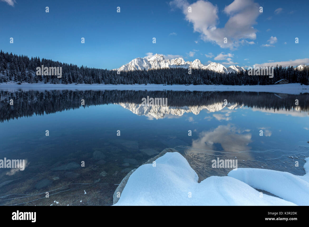 Woods et des sommets enneigés se reflètent dans l'eau claire du lac Palù Valtellina Zone Val Malenco de Lombardie Italie Europe Banque D'Images