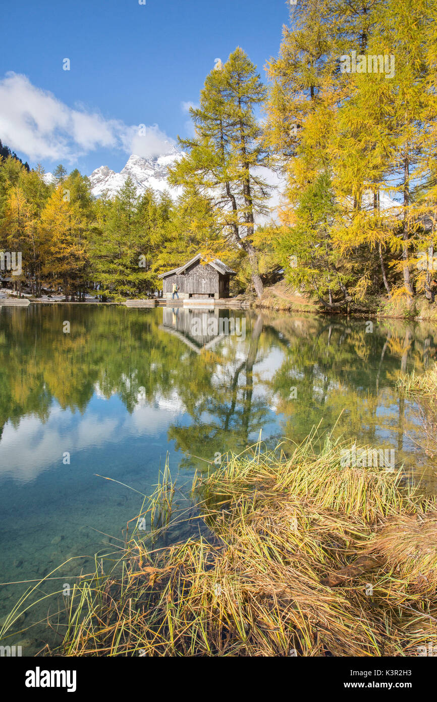 Chalet en bois colorés et arbres se reflétant dans Lai da Palpuogna Col d'Albula Bergün Canton des Grisons Engadine Suisse Europe Banque D'Images