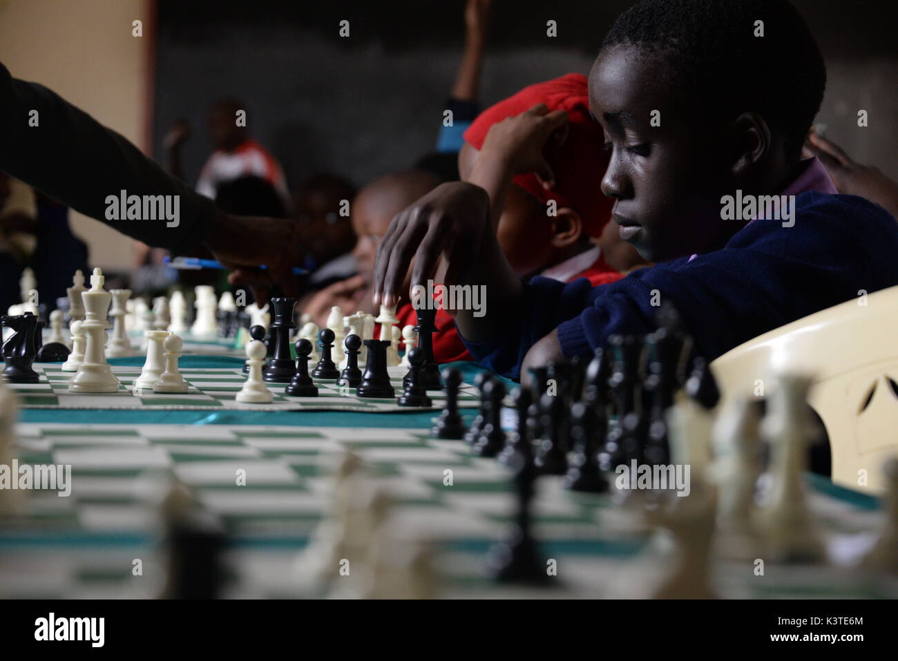 Un jeune kényan jouant aux échecs lors d'un tournoi de Mukuru Kwa Njenga, un bidonville de Nairobi (Kenya), 15 juillet 2017. Les Ougandais de l'adolescent sont également participants à ce tournoi. Pour un long séjour en Ouganda, d'échecs a été réservé à l'élite instruite seulement. Avec l'aide de Robert Katendes une fille nommée Nadia Mutesi est devenue une star des échecs. Aujourd'hui, elle inspire toute une génération d'enfants en Ouganda. Photo : Gioia Forster/dpa Banque D'Images