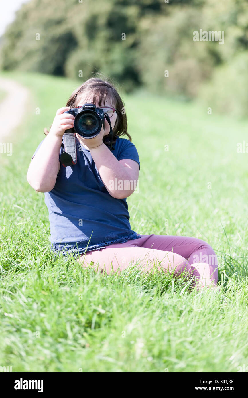 Jeune fille à l'aide d'un appareil photo Canon. Banque D'Images