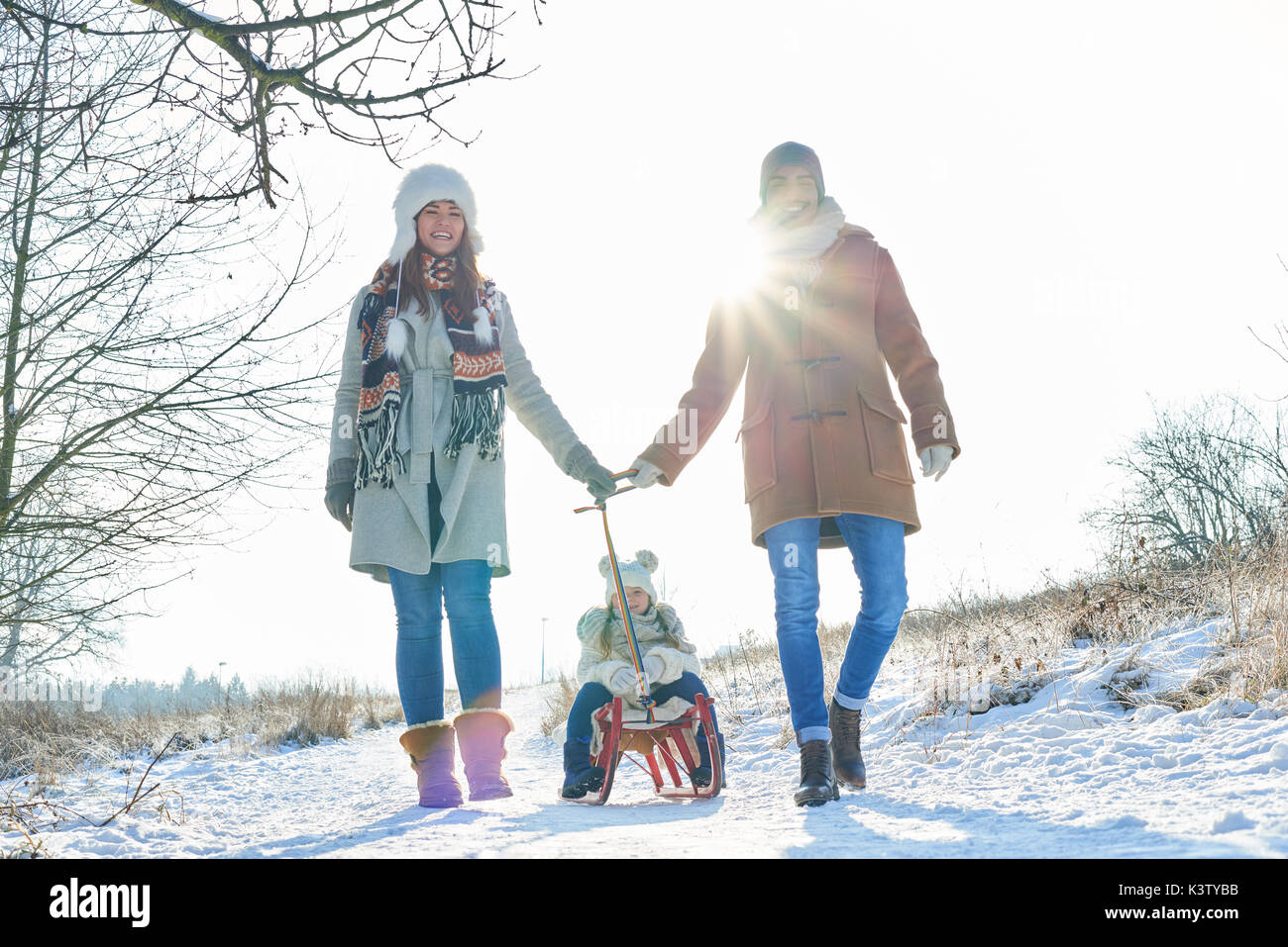Famille faire une promenade dans la neige avec les enfants sur un traîneau Banque D'Images