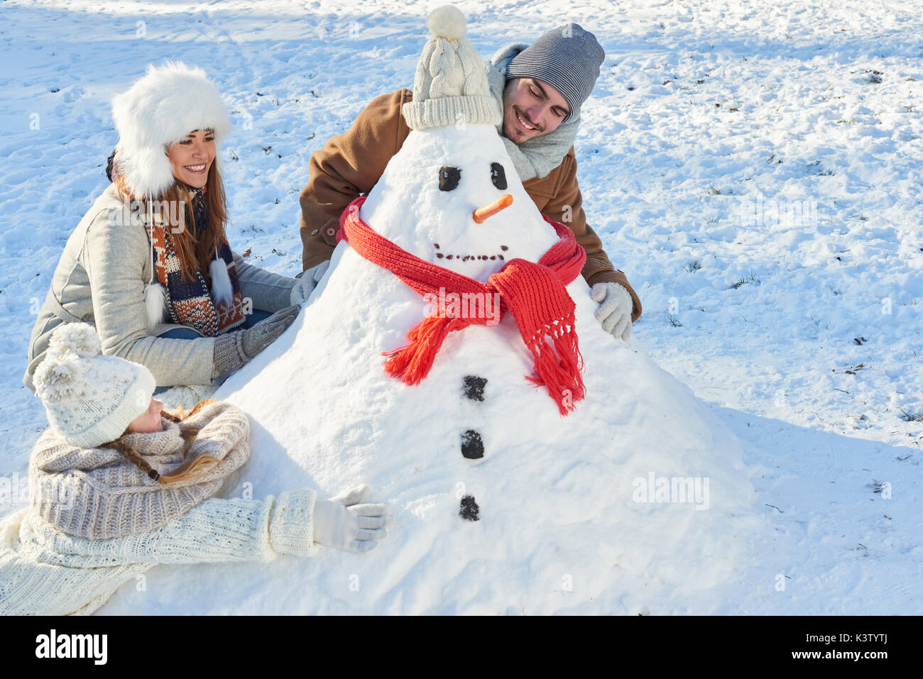 Les parents et l'enfant construire bonhomme en hiver en famille Banque D'Images