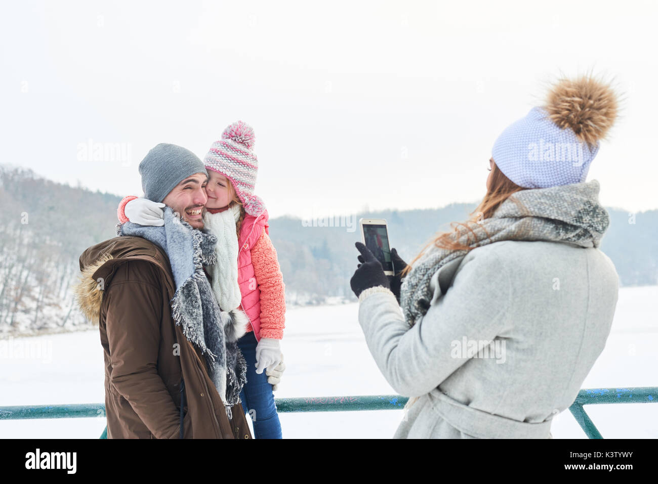 Mère prend des photopgraph avec la famille en hiver smartphone Banque D'Images