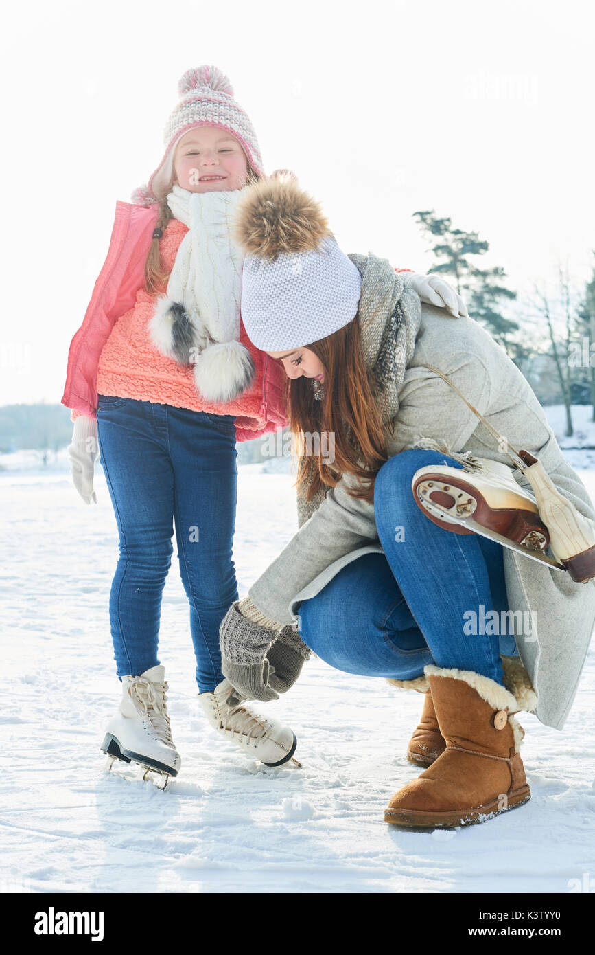 Mère fille chaussures de bind avant le patin à glace Banque D'Images