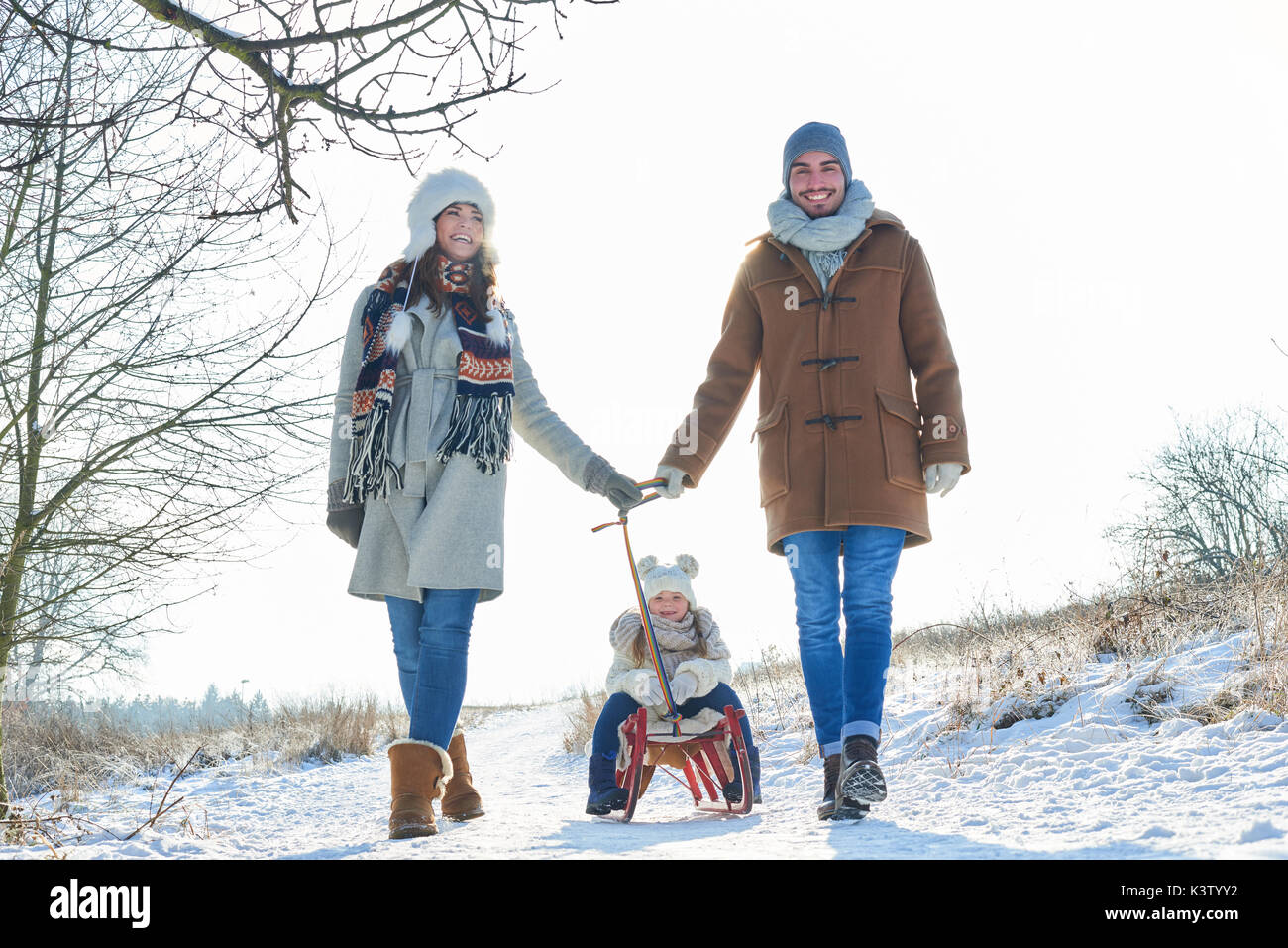 Famille faites une balade hivernale dans la neige avec les enfants sur un traîneau Banque D'Images