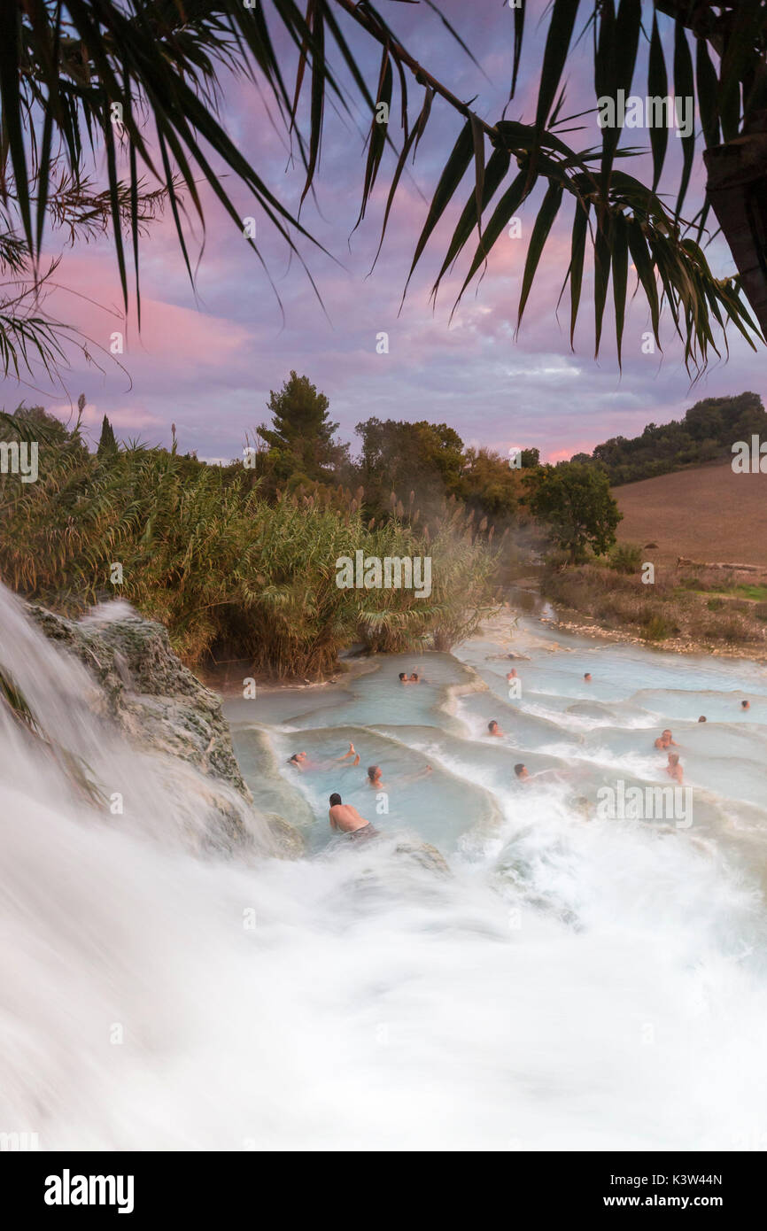 Les touristes se détendre pendant le coucher du soleil à termal Cascade Mill de Saturnia. Cascade Mill(Cascata del Mulino),Saturnia, Manciano, province de Grosseto, Toscane, Italie, Europe Banque D'Images
