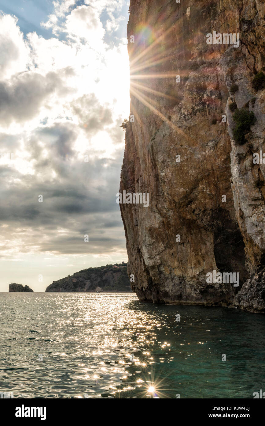 L'Italie, Campanie, Cilento, soleil disparaît derrière falaise sur la mer. Banque D'Images