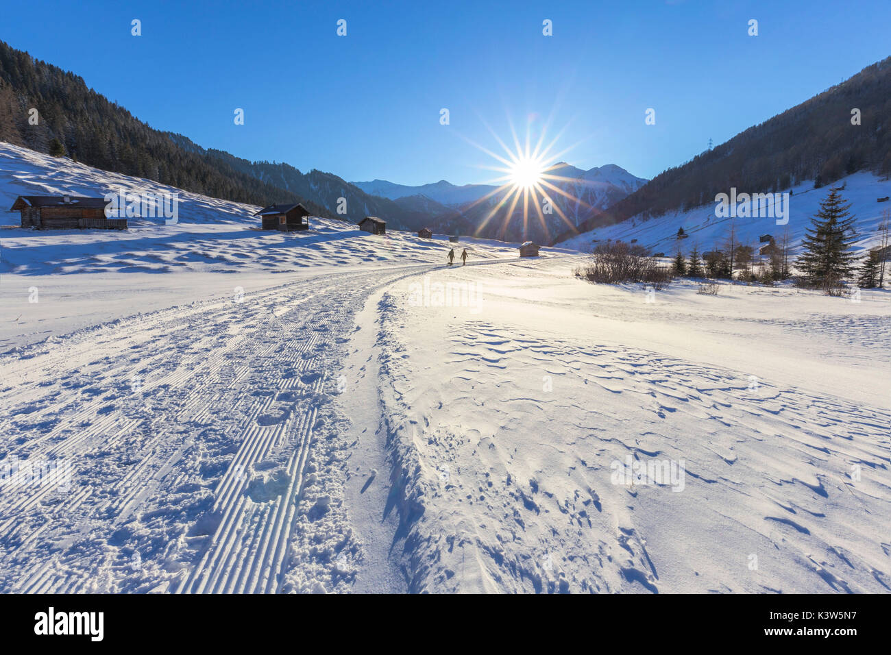 Les gens déambuler parmi le plateau des huttes, éclairé par le soleil couchant. Pfunds Tschey, Pfunds, l'Inntal, Tirol, Osterreich, Europe Banque D'Images
