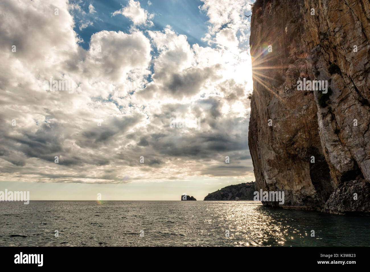 L'Italie, Campanie, Cilento, soleil disparaît derrière falaise sur la mer. Banque D'Images