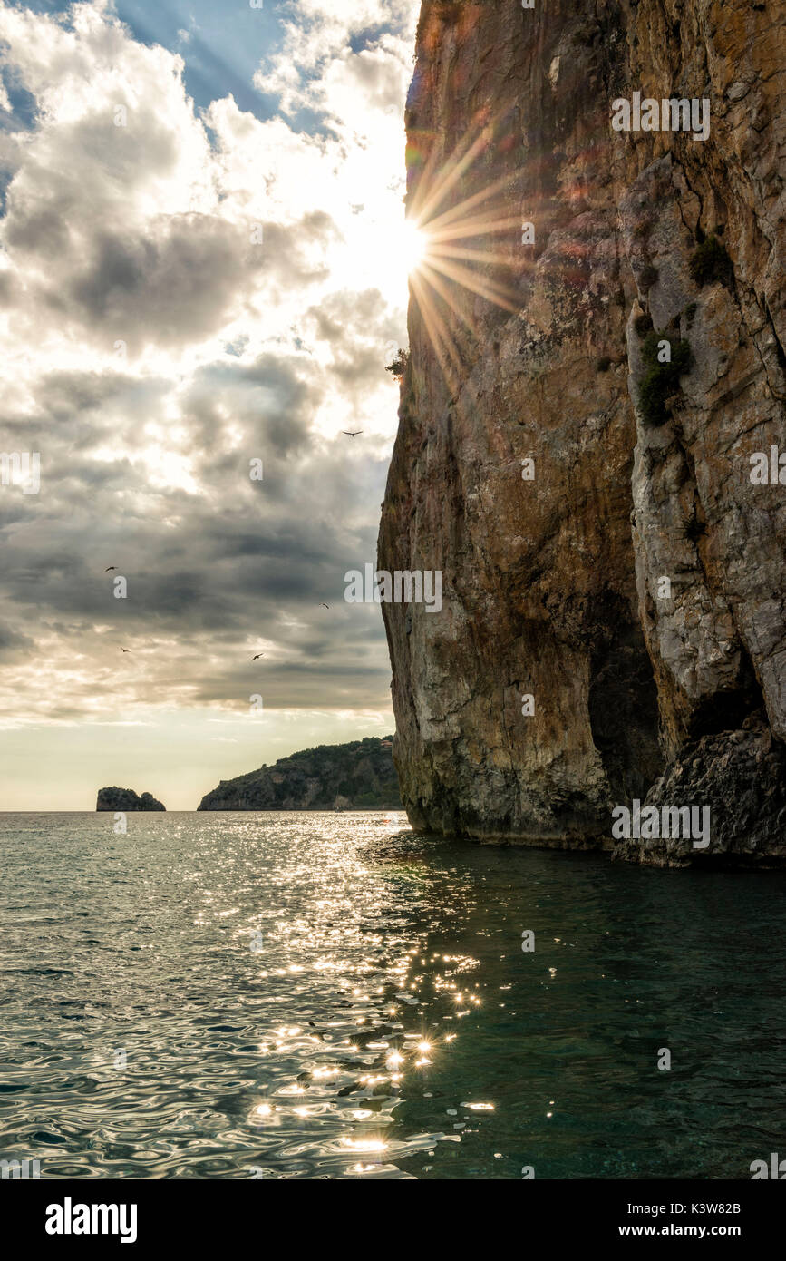 L'Italie, Campanie, Cilento, soleil disparaît derrière falaise sur la mer. Banque D'Images