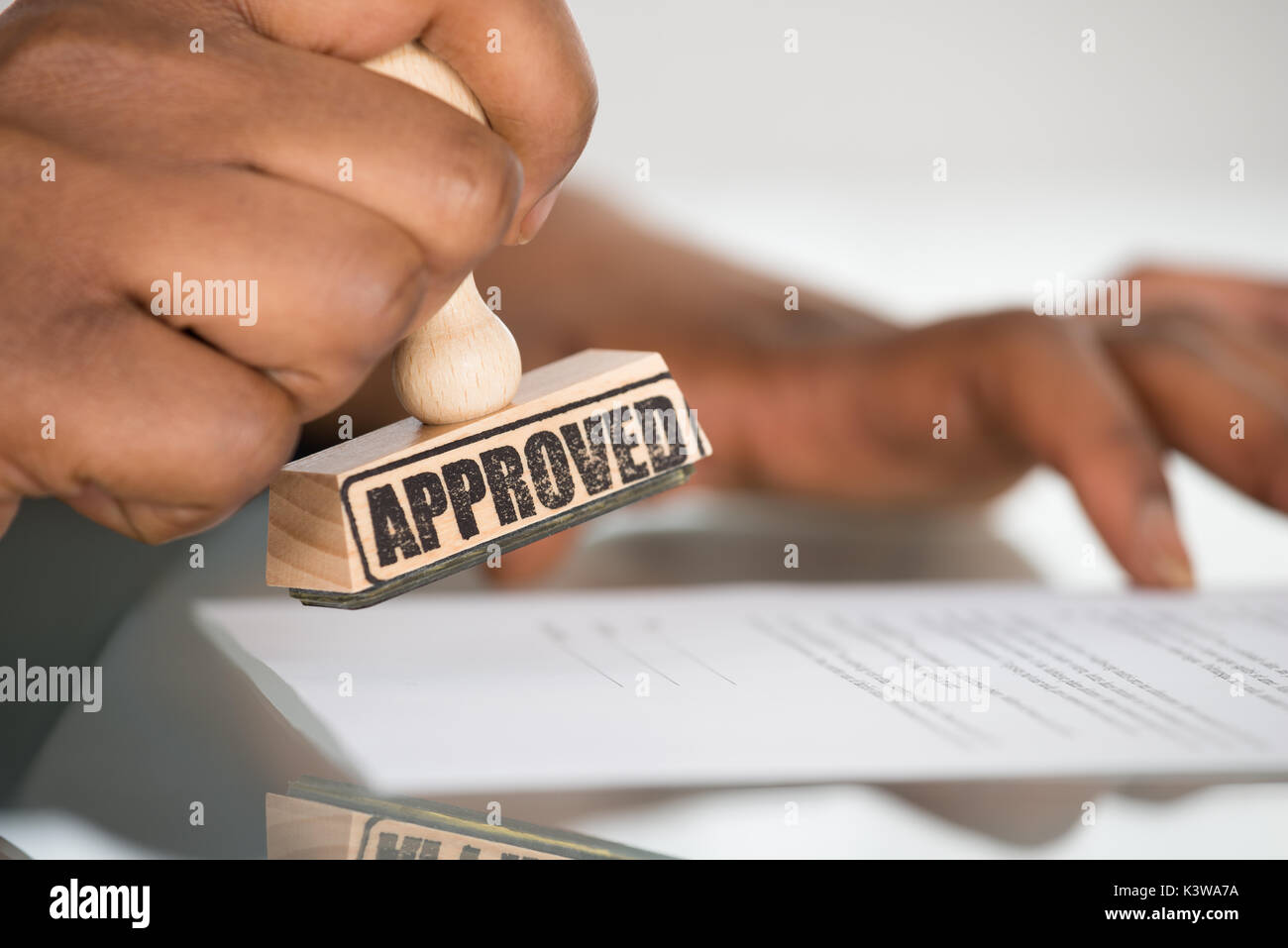 Close-up of a person's Hand piétinement sur le formulaire de contrat approuvé Banque D'Images