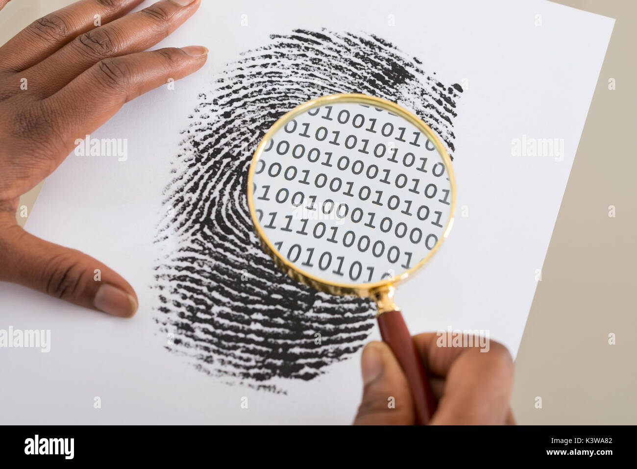 Close-up de personne à l'aide de loupe pour vérifier le code binaire dans l'impression de doigt Banque D'Images