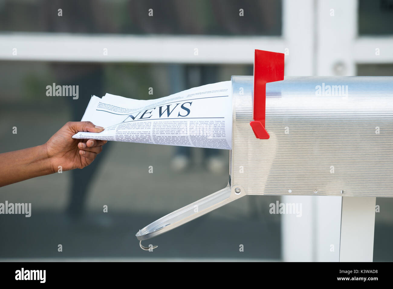 Close-up of Person's Hand ouvrant la boîte aux lettres pour retirer le journal Banque D'Images