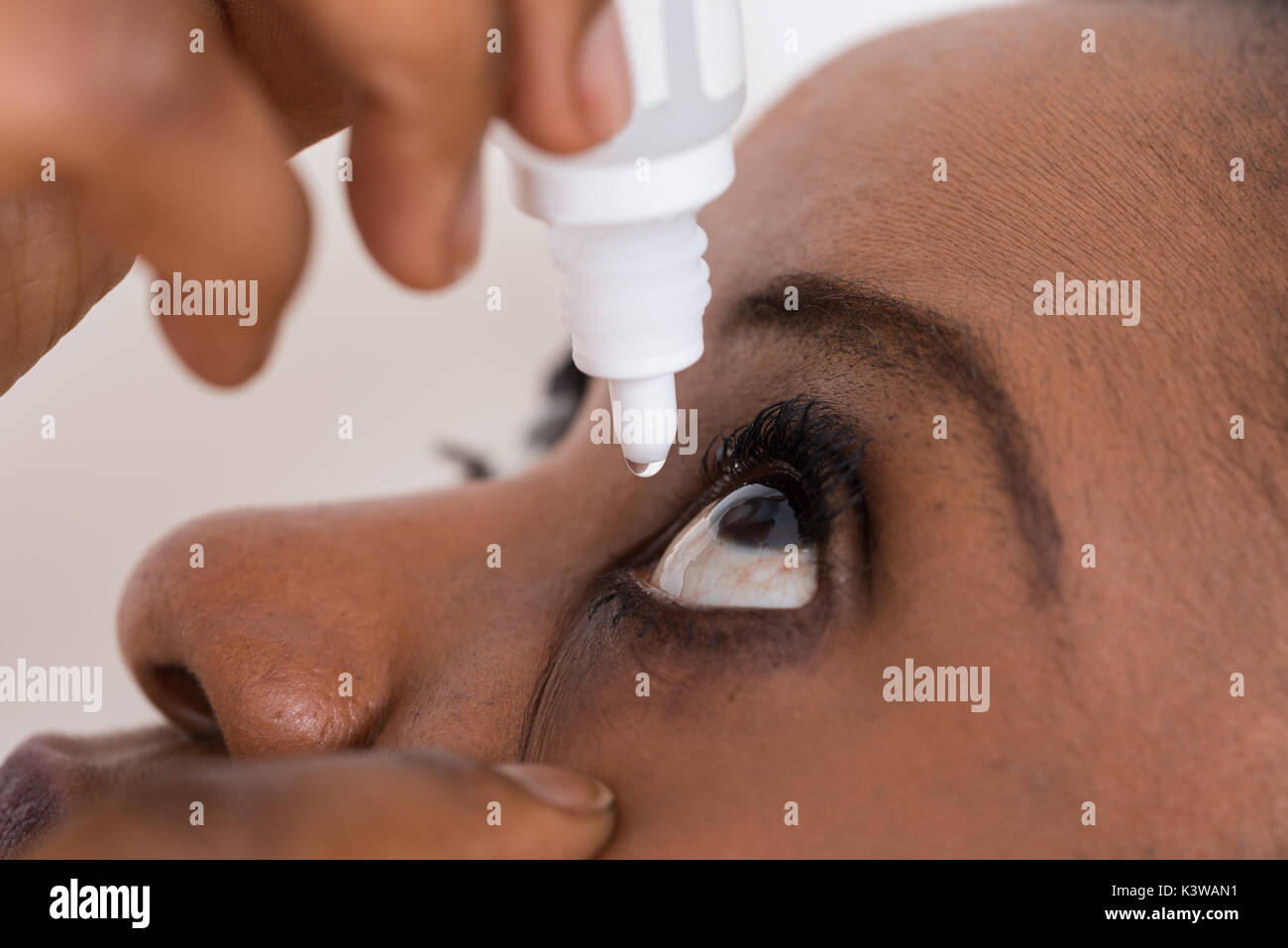 Close-up of Young African Woman Using eye Drop Banque D'Images