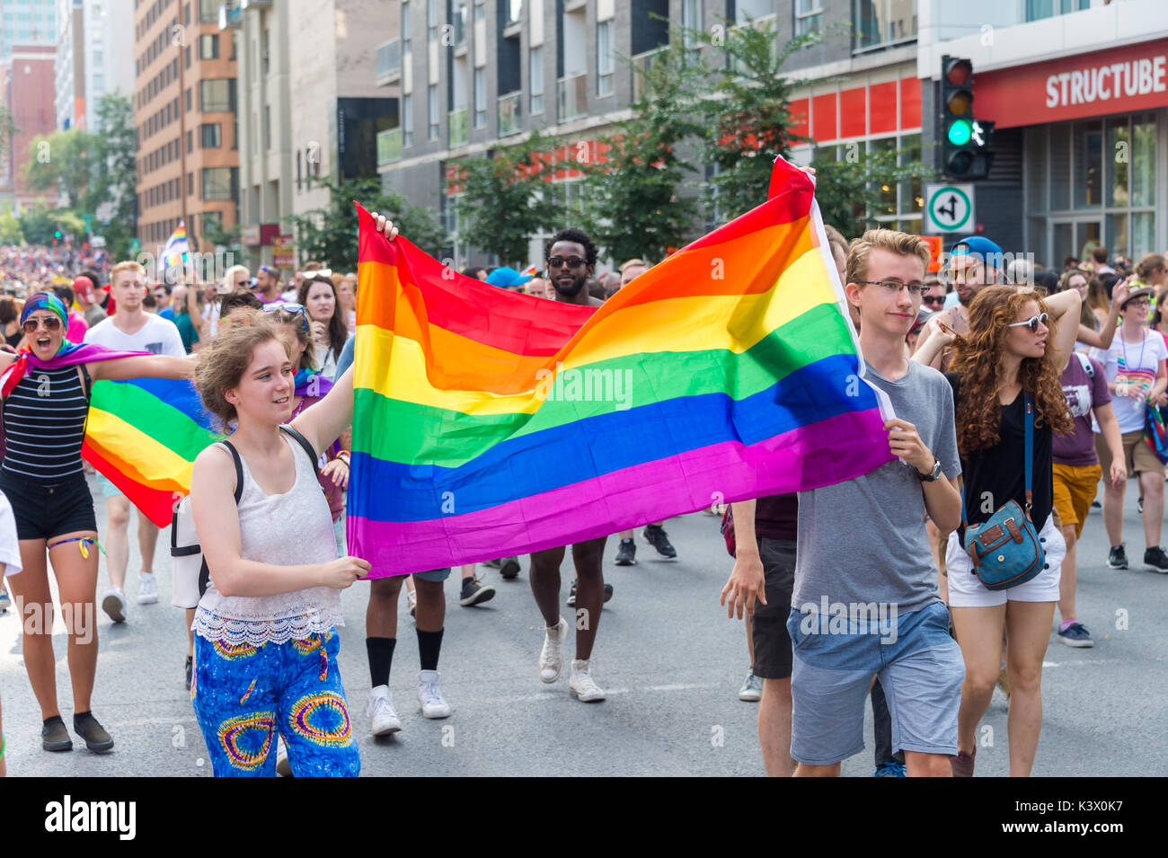 Montréal, Canada - 20 août 2017 : deux jeunes personnes sont titulaires d'un grand drapeau arc-en-ciel gay Gay Pride Parade à Montréal Banque D'Images