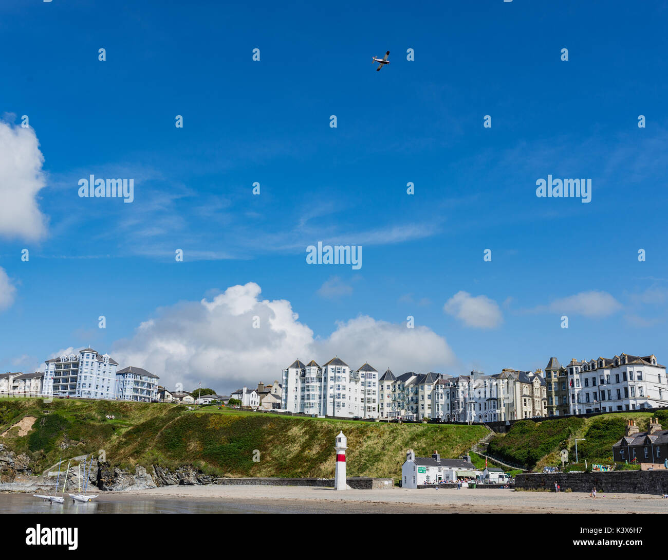 Vue de la plage et de la promenade de Port Erin maisons dans la distance, air-plane dans le ciel Banque D'Images