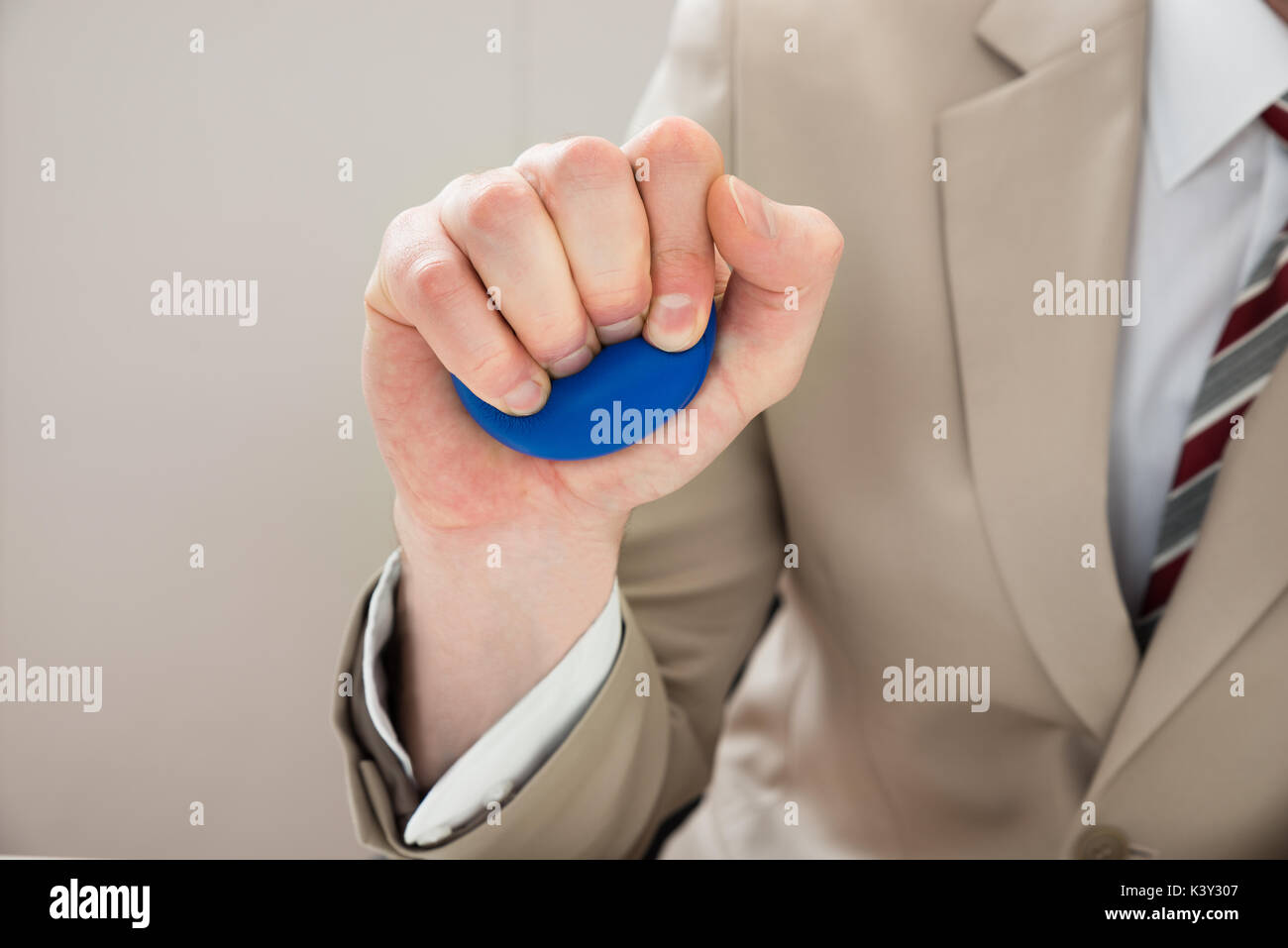 Close-up d'affaires Part Squeezing Stressball dans la main Banque D'Images
