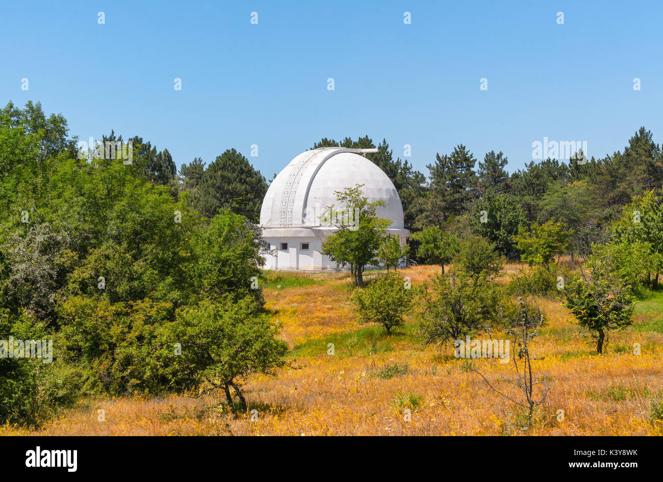 Télescope avec un dôme fermé entouré d'arbres. Coronographe dans Observatory Banque D'Images