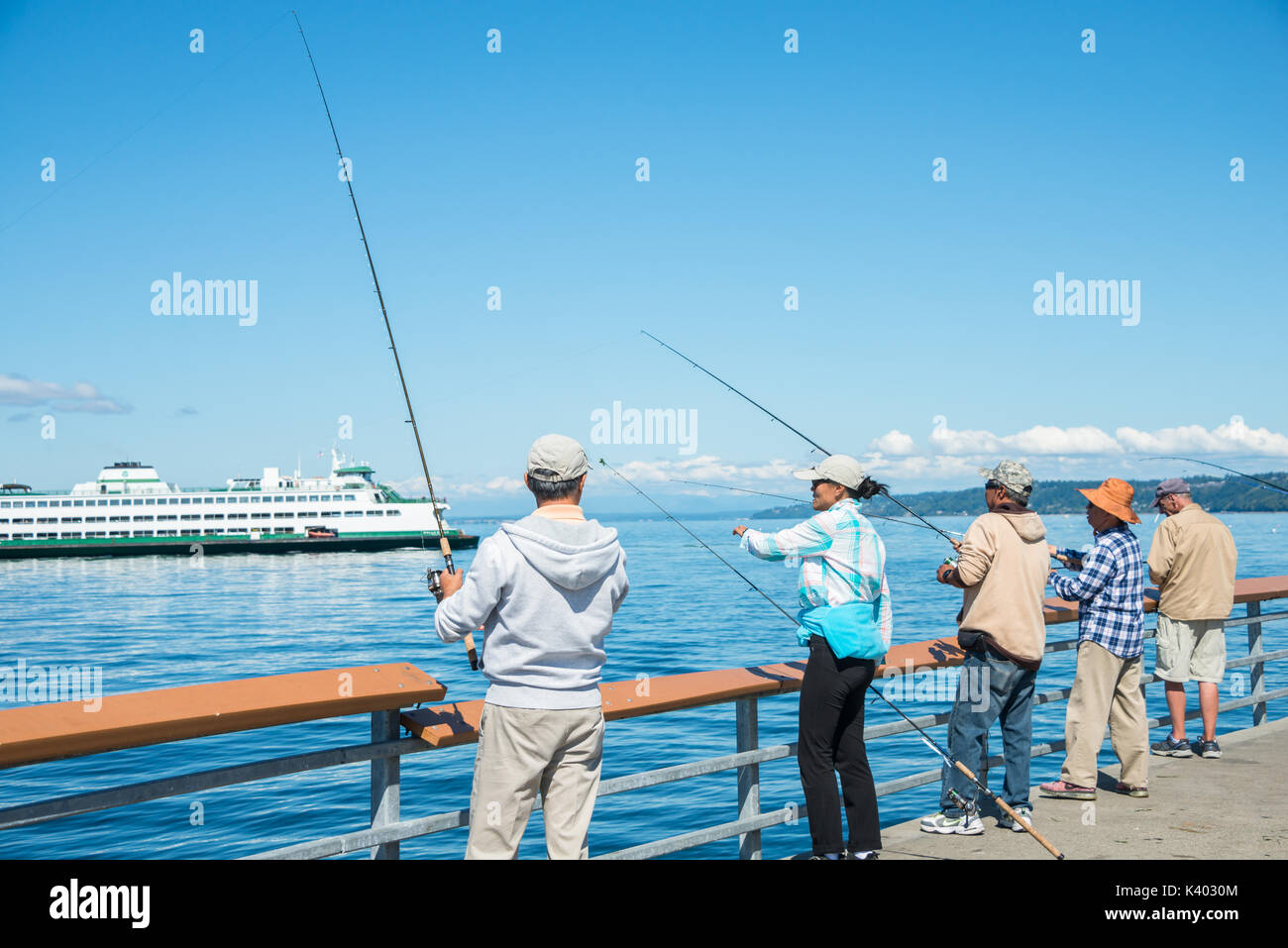 Les hommes et les femmes La pêche au large de l'embarcadère de ferry avec en arrière-plan, Edmonds, Washington Banque D'Images