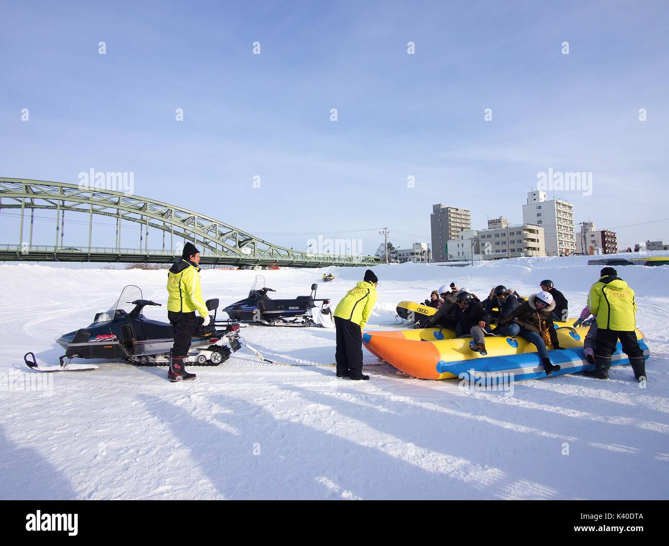 Les visiteurs s'amusant avec banana boat sur la glace neige tiré par téléphonie mobile au Festival d'hiver d'Asahikawa, Hokkaido, Japon Banque D'Images