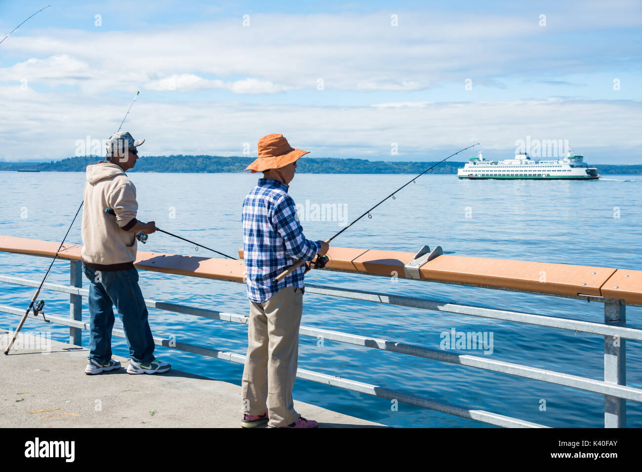 Mari et femme sur la jetée de pêche avec Washington State Ferry en arrière-plan Banque D'Images