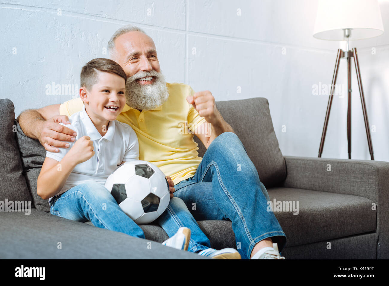 Grand-père et petit-fils d'enracinement de leur équipe de football préférée Banque D'Images