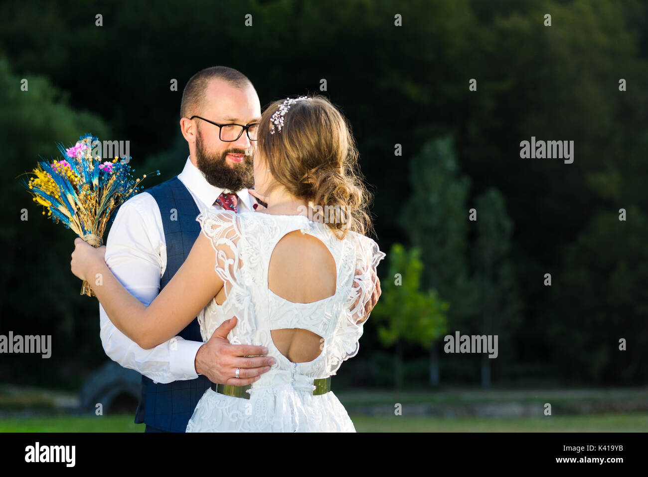 Mariée et le marié dans l'heure du coucher du soleil à hug romantique Banque D'Images