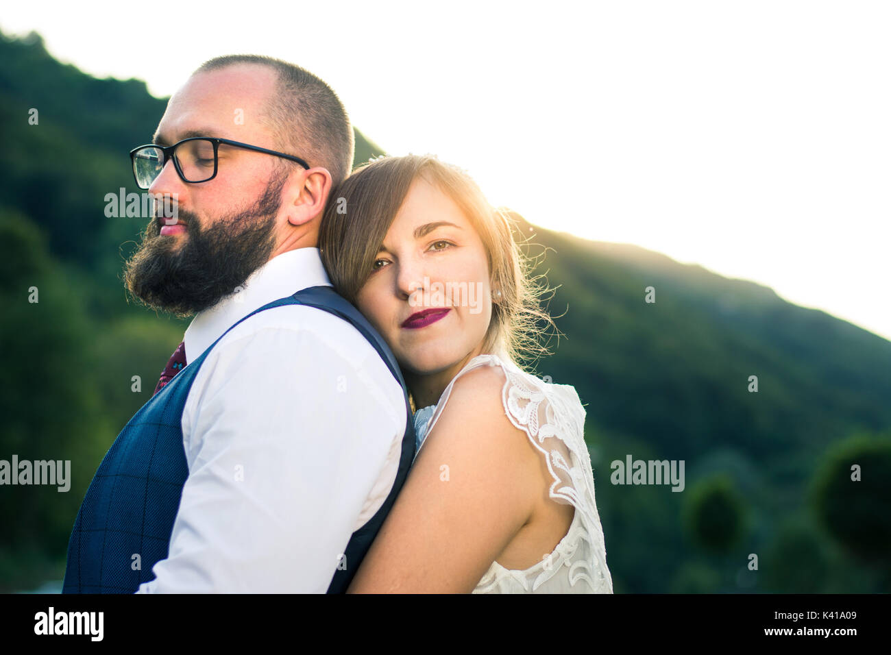 Mariée et le marié dans l'heure du coucher du soleil à hug romantique Banque D'Images