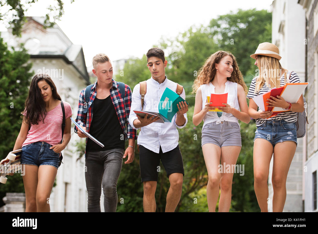 Groupe d'étudiants adolescents attrayant à pied de l'université. Banque D'Images