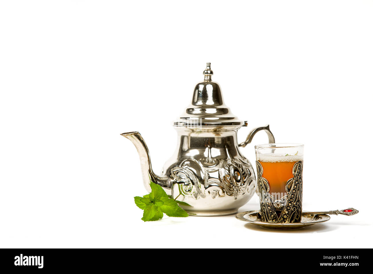 Vrai thé à la menthe marocain dans la coupe originale et une théière sur le fond blanc Banque D'Images