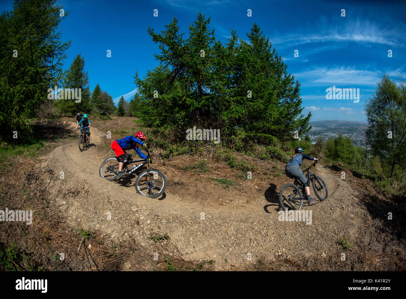 Un groupe de cyclistes de montagne monter un sentier poussiéreux au Bikepark de galles près de la ville de Merthyr Tydfil au Pays de Galles. Banque D'Images