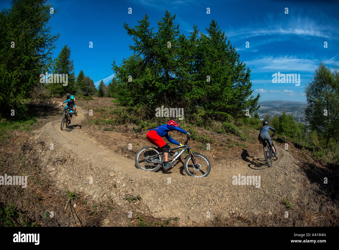Un groupe de cyclistes de montagne monter un sentier poussiéreux au Bikepark de galles près de la ville de Merthyr Tydfil au Pays de Galles. Banque D'Images