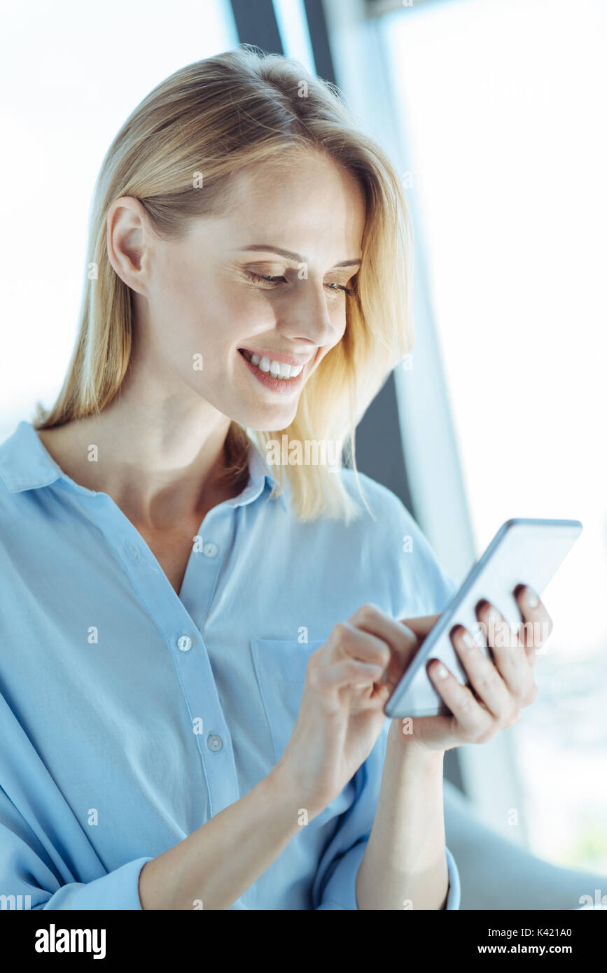 Cheerful woman reading les échéanciers de ses réseaux sociaux Banque D'Images