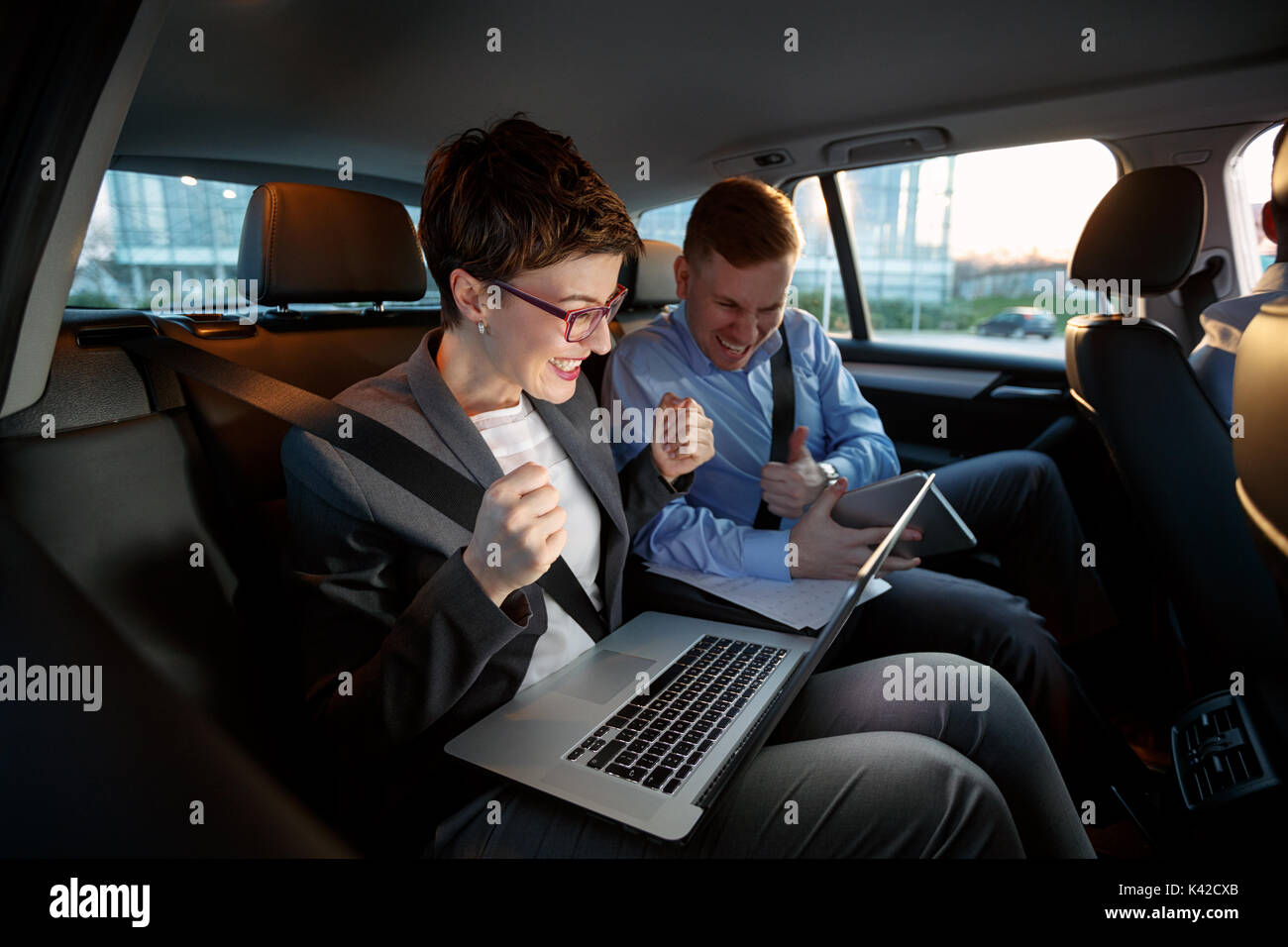 Businesspeople looking at laptop in car en voyage d'affaires Banque D'Images