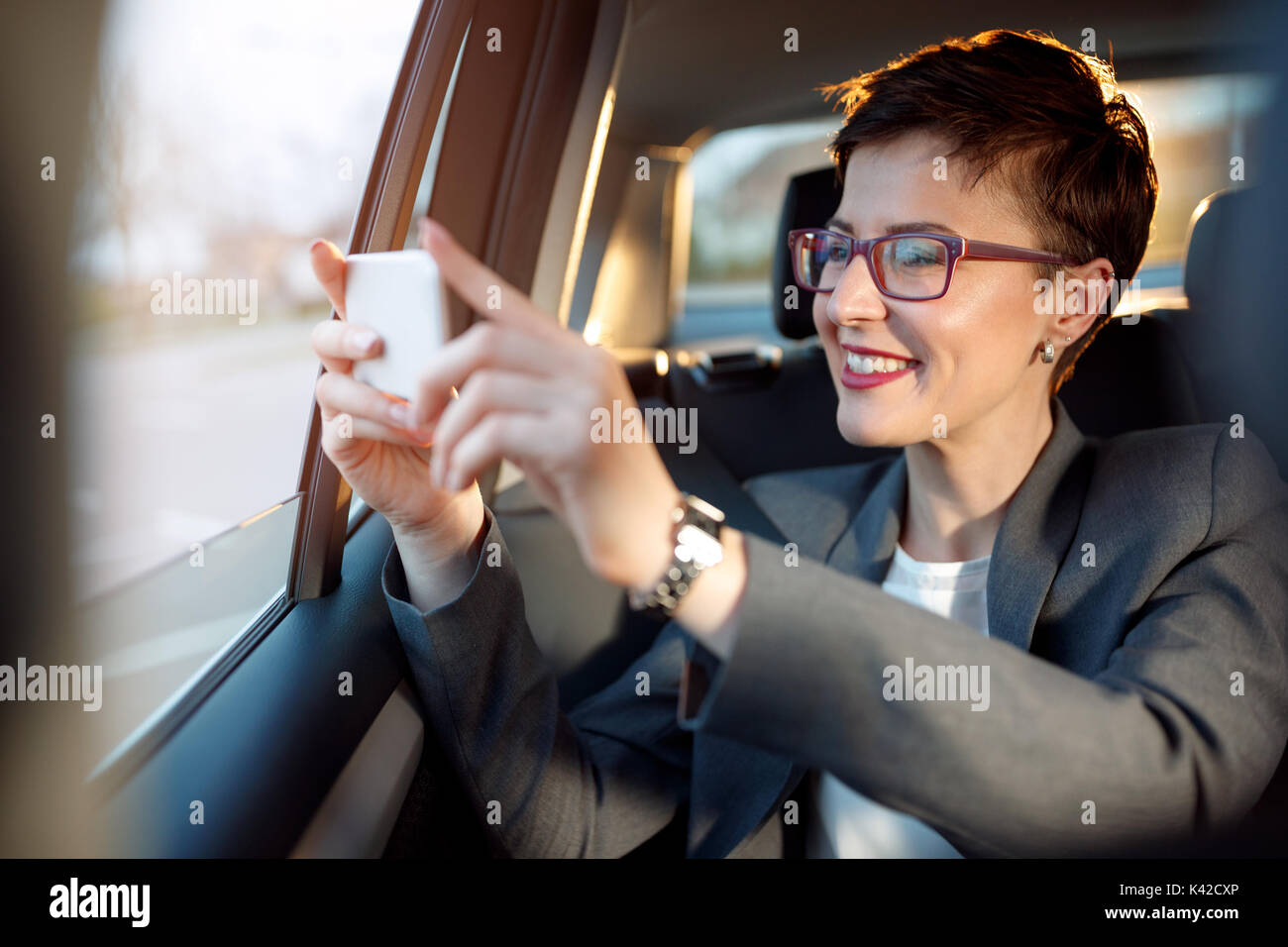 Femme d'affaires profiter sur le voyager et prendre des photos à partir d'une voiture Banque D'Images