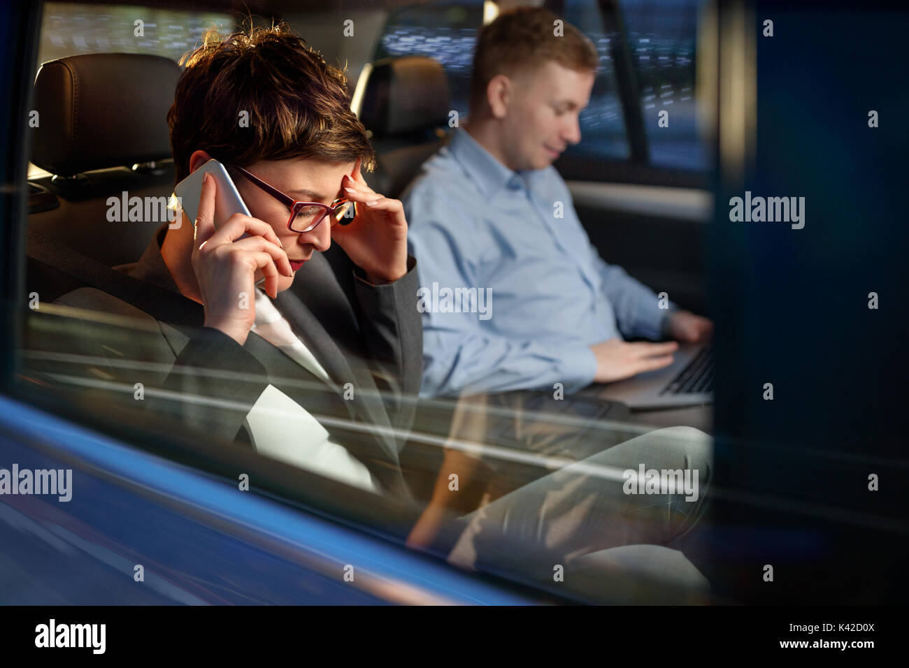 Nuit de travail- fatigué business woman utilisation smartphone dans la voiture Banque D'Images