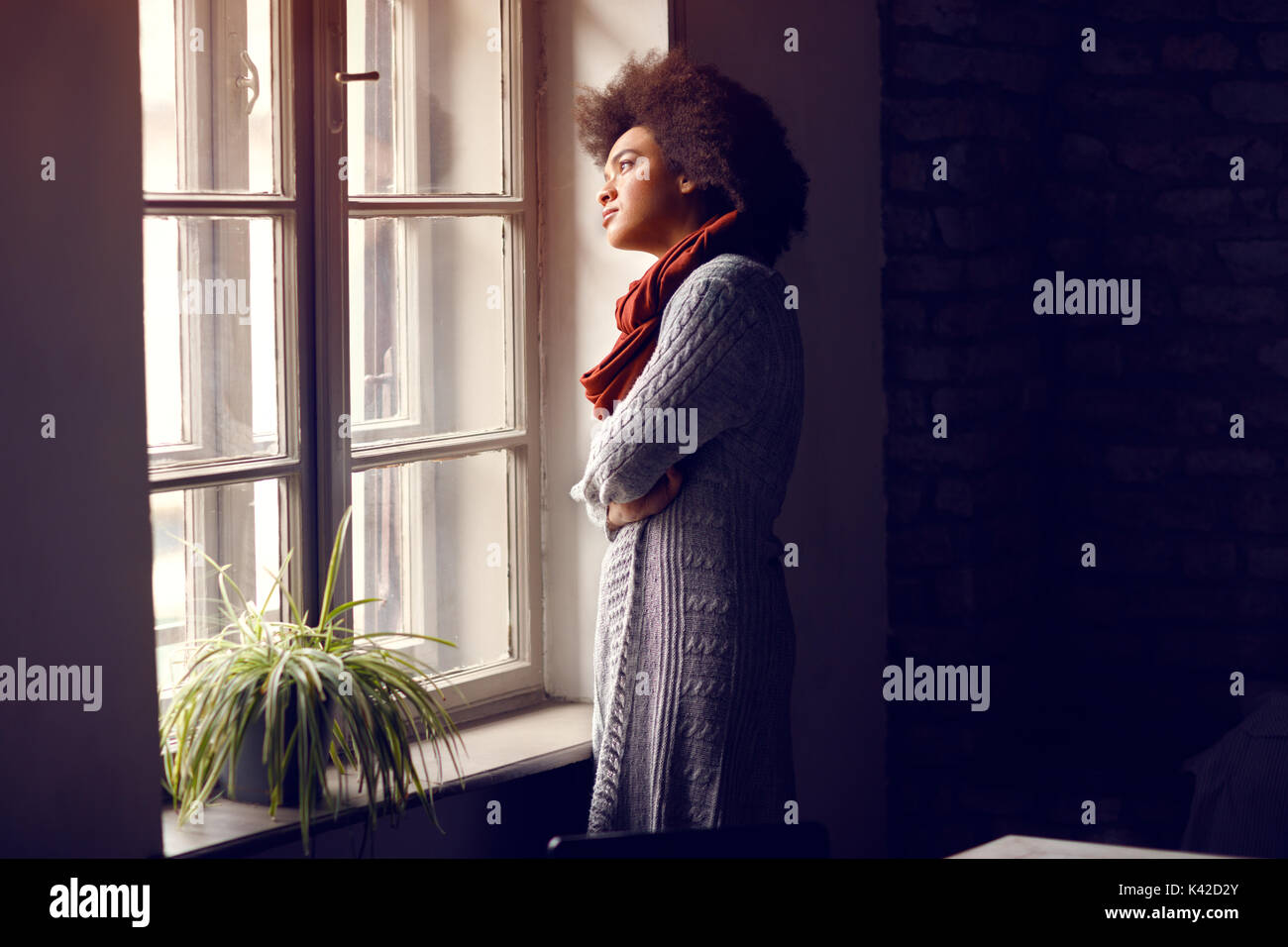 Femme regarder par la fenêtre in office Banque D'Images