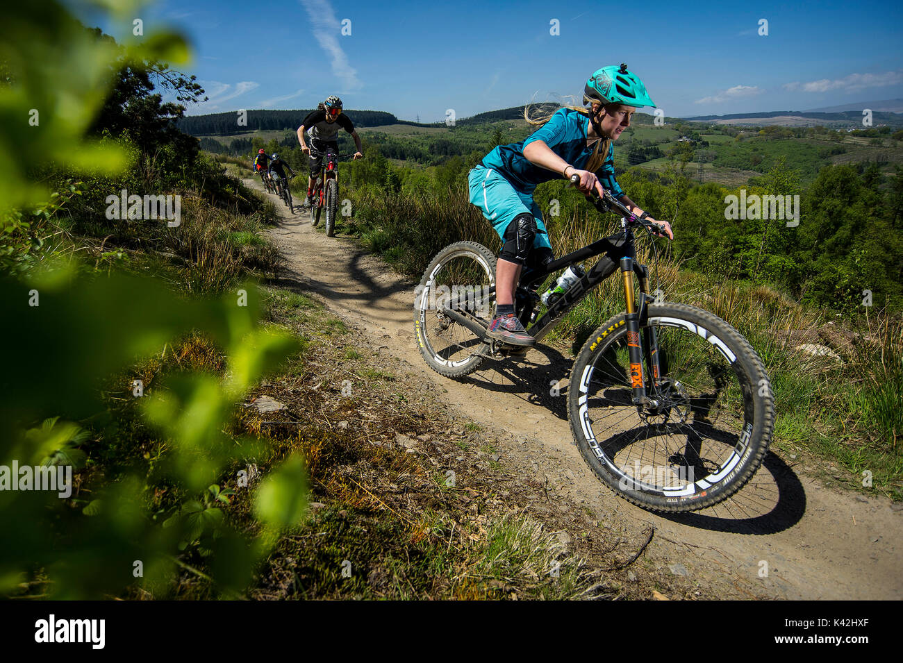 Un vélo de montagne des femmes à la tête d'un groupe de cavaliers le long d'un sentier au Bikepark de galles près de la ville de Merthyr Tydfil. Banque D'Images