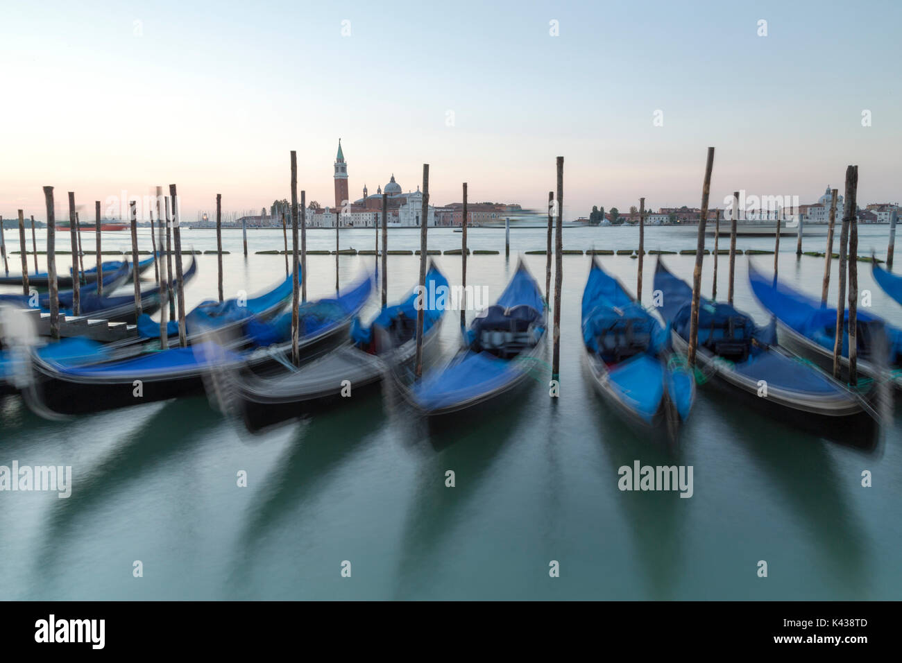 L'Italie, Venise, gondoles amarrées vue transmis vers l'Isola di San Giorgio Maggiore au lever du soleil. Banque D'Images