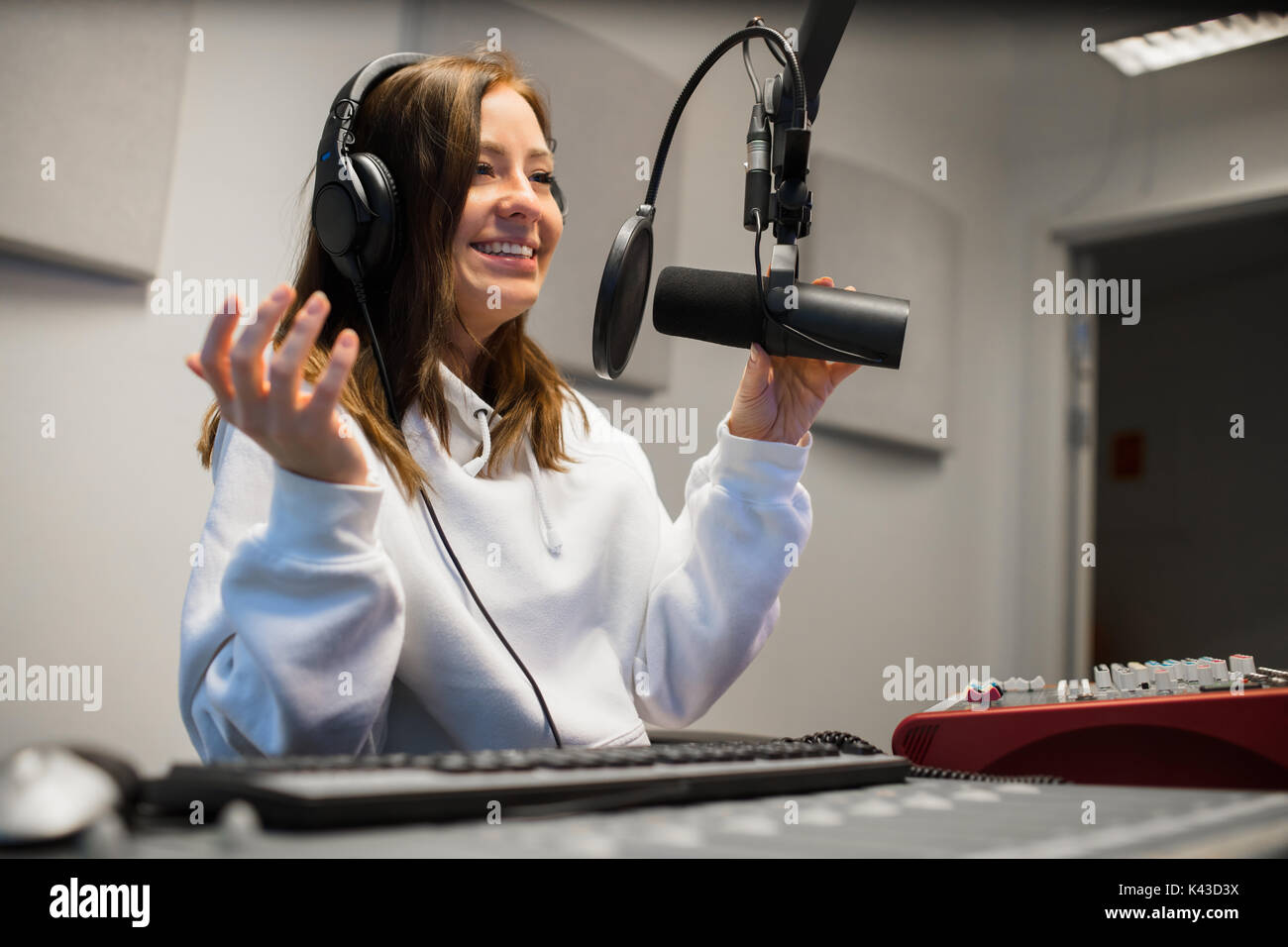 Femme Jockey communiquant sur micro de studio de Radio Banque D'Images