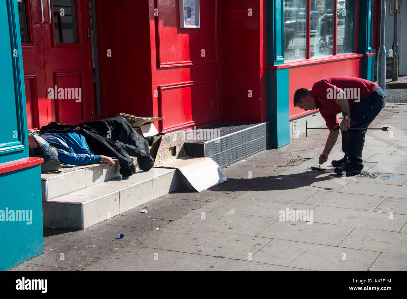 Les habitants de la rue du centre-ville de Brighton. Un homme vérifie l'alimentation en eau d'une entreprise pendant que quelqu'un dort dans une porte. Credit:Terry Applin Banque D'Images