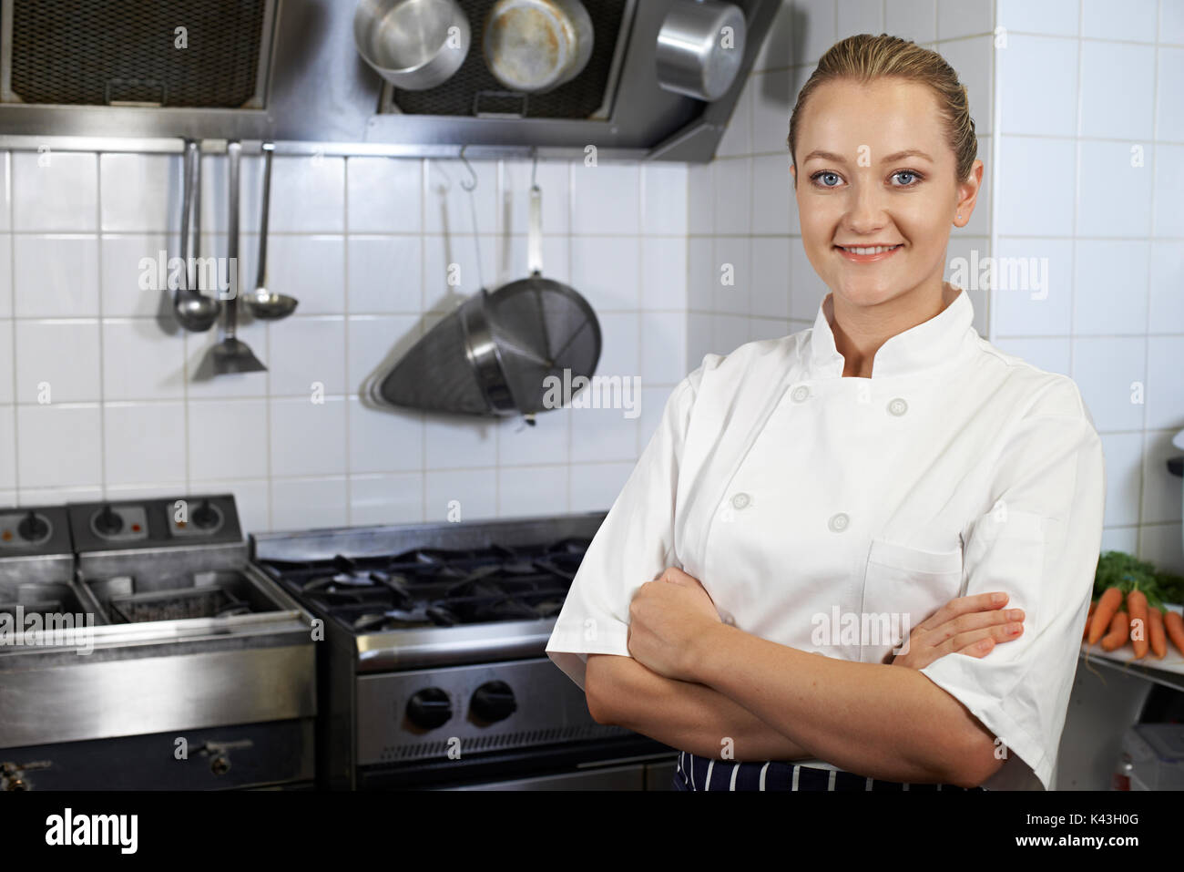 Portrait of Female Chef Standing In Kitchen Banque D'Images