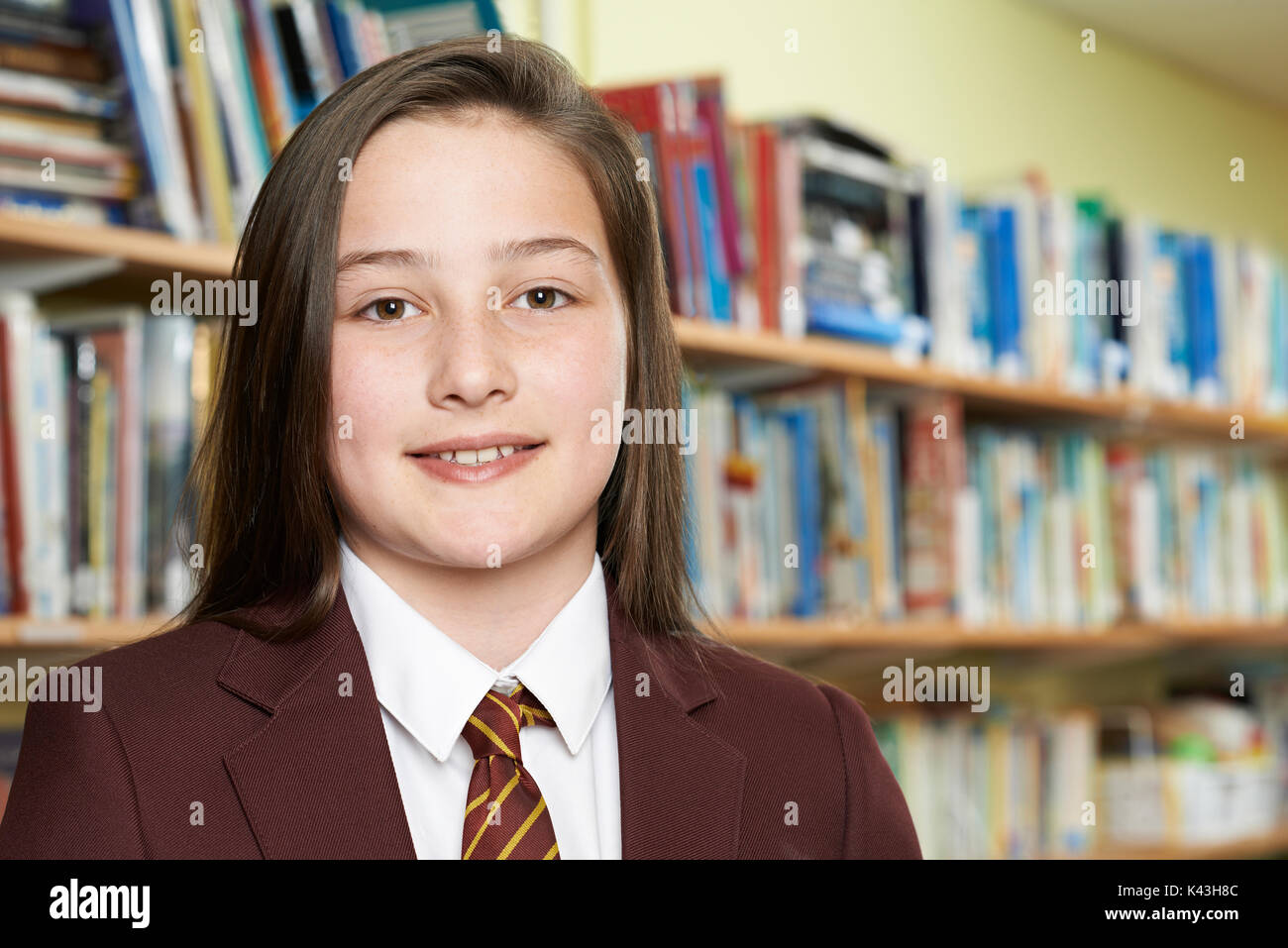 Portrait of Girl Wearing School Uniform In Library Banque D'Images