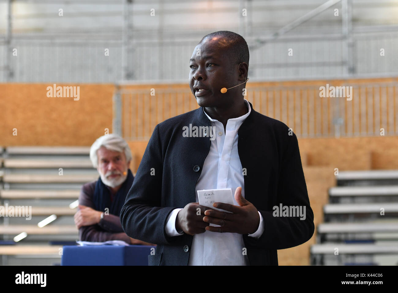 Berlin, Allemagne. 16Th Jun 2017. L'architecte Francis Kéré explique les plans d'un atellitentheater «' du Volksbuehne dans un hangar de l'ancien aéroport de Tempelhof pendant un communiqué de parler à Berlin, Allemagne, 4 septembre 2017. Directeur artistique Chris Dercon peut être vu à l'arrière. Photo : Paul Zinken/dpa/Alamy Live News Banque D'Images