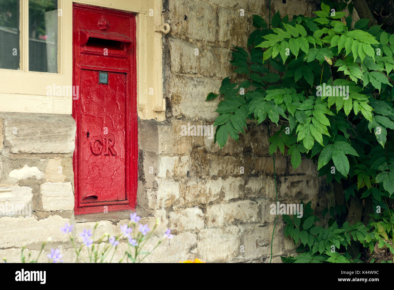 Un vieux post box encastrée dans le mur de la paroi de la maintenant fermée sous bureau de poste à l'woodchester dans les Cotswolds, Gloucestershire Banque D'Images